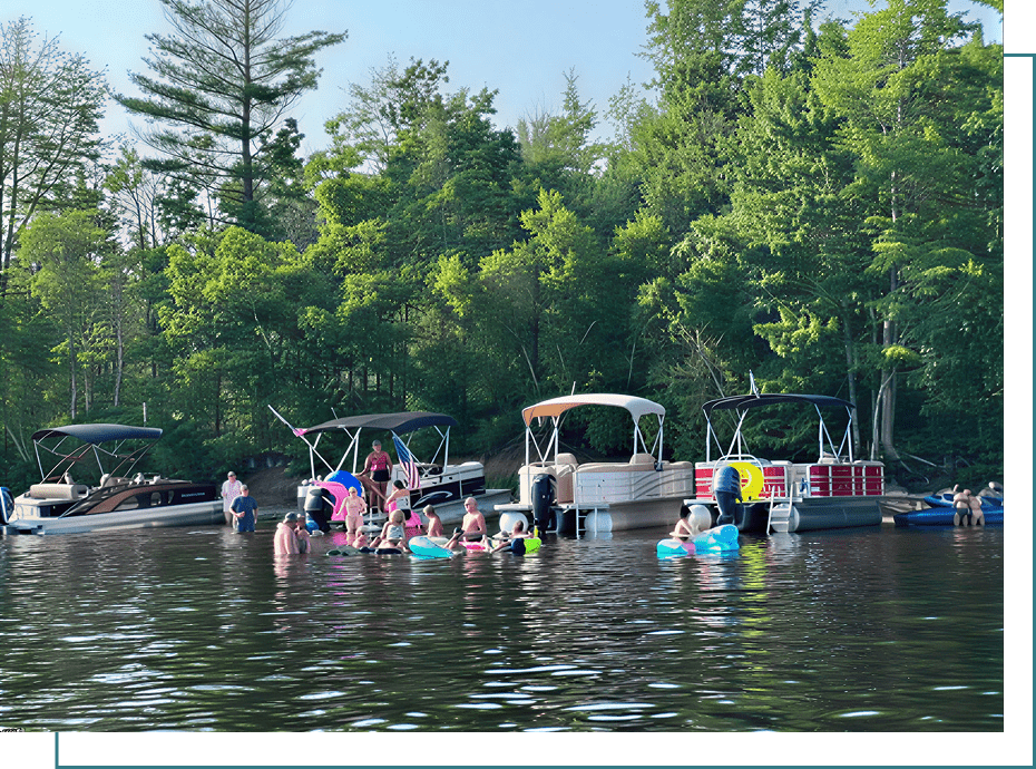 People enjoying lake with boats anchored nearby